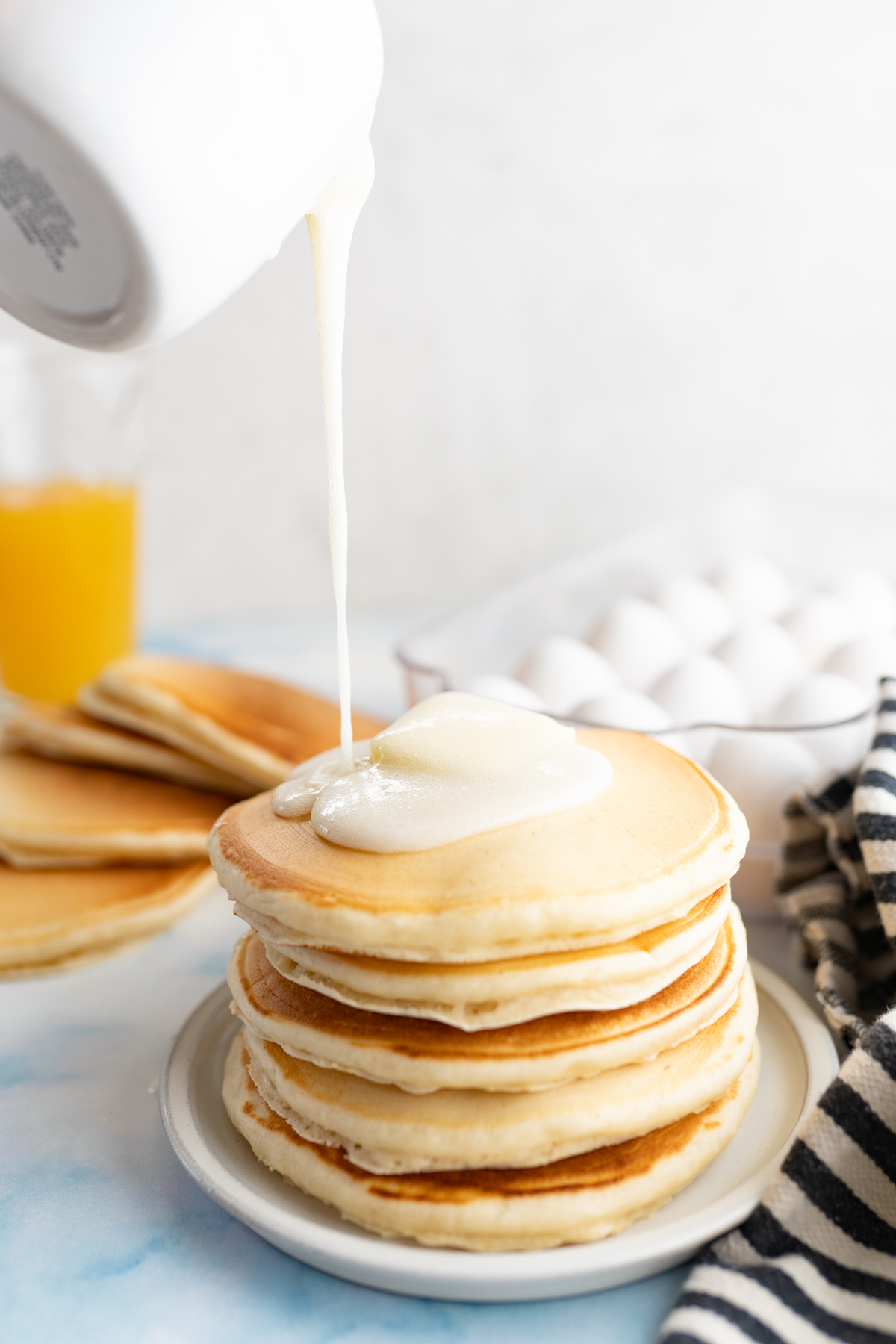 Image of buttermilk syrup being poured onto pancakes made from scratch. 