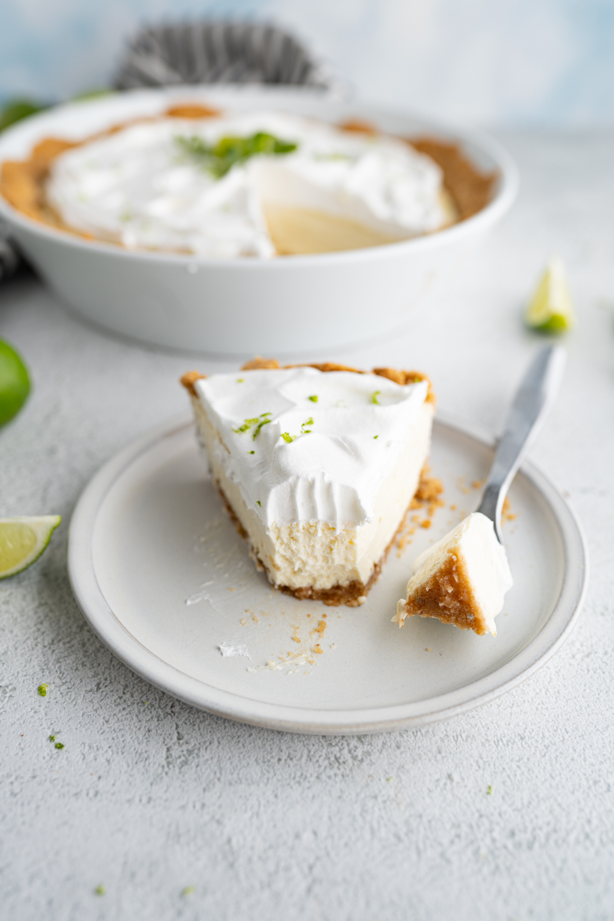 A slice of key lime pie with a bite taken out of it. 