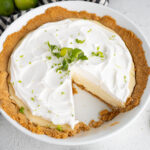 A homemade key lime pie with one slice out of it.