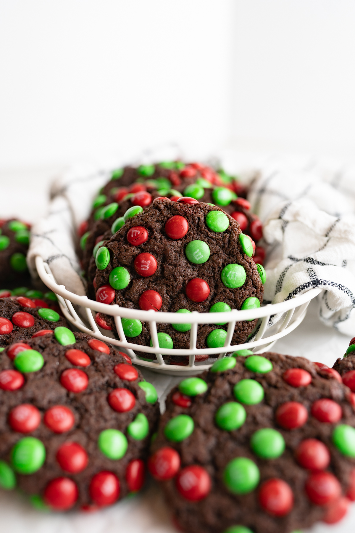 A chocolate m&m cookie for Christmas in a white basket. 