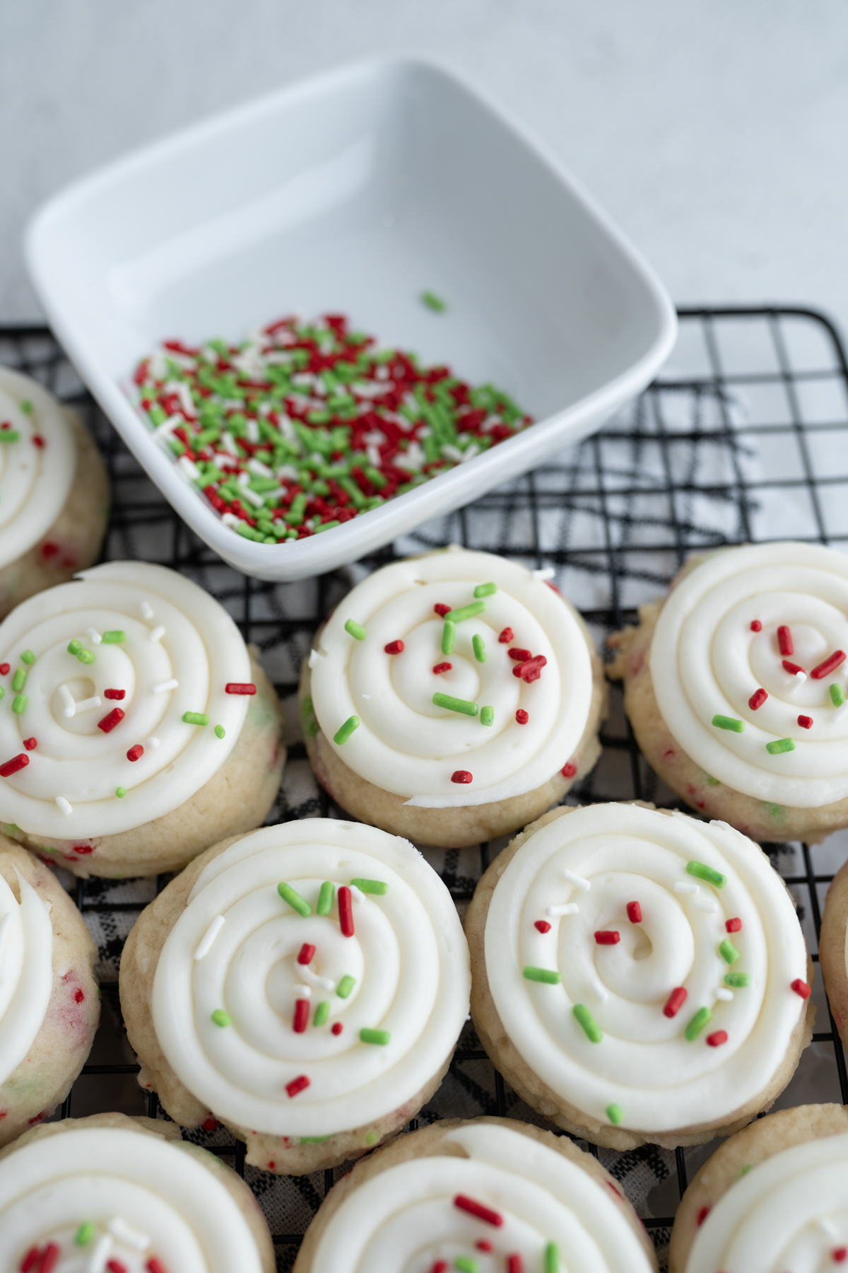 Cake batter cookies next to a bowl of christmas sprinkles. 
