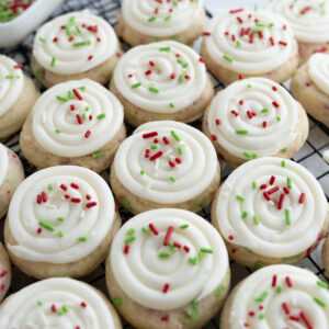 Close up of a grid of birthday cake cookies decorated with Christmas sprinkles.