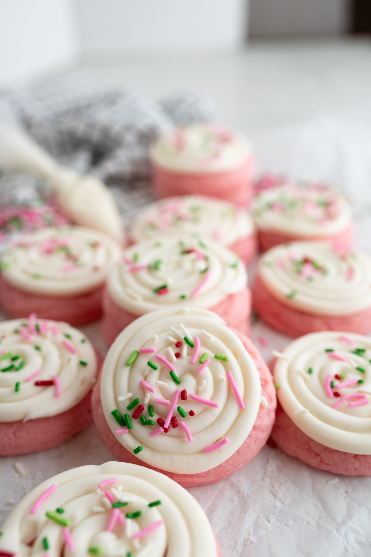 Cute pink cookies with white frosting and green sprinkles. 