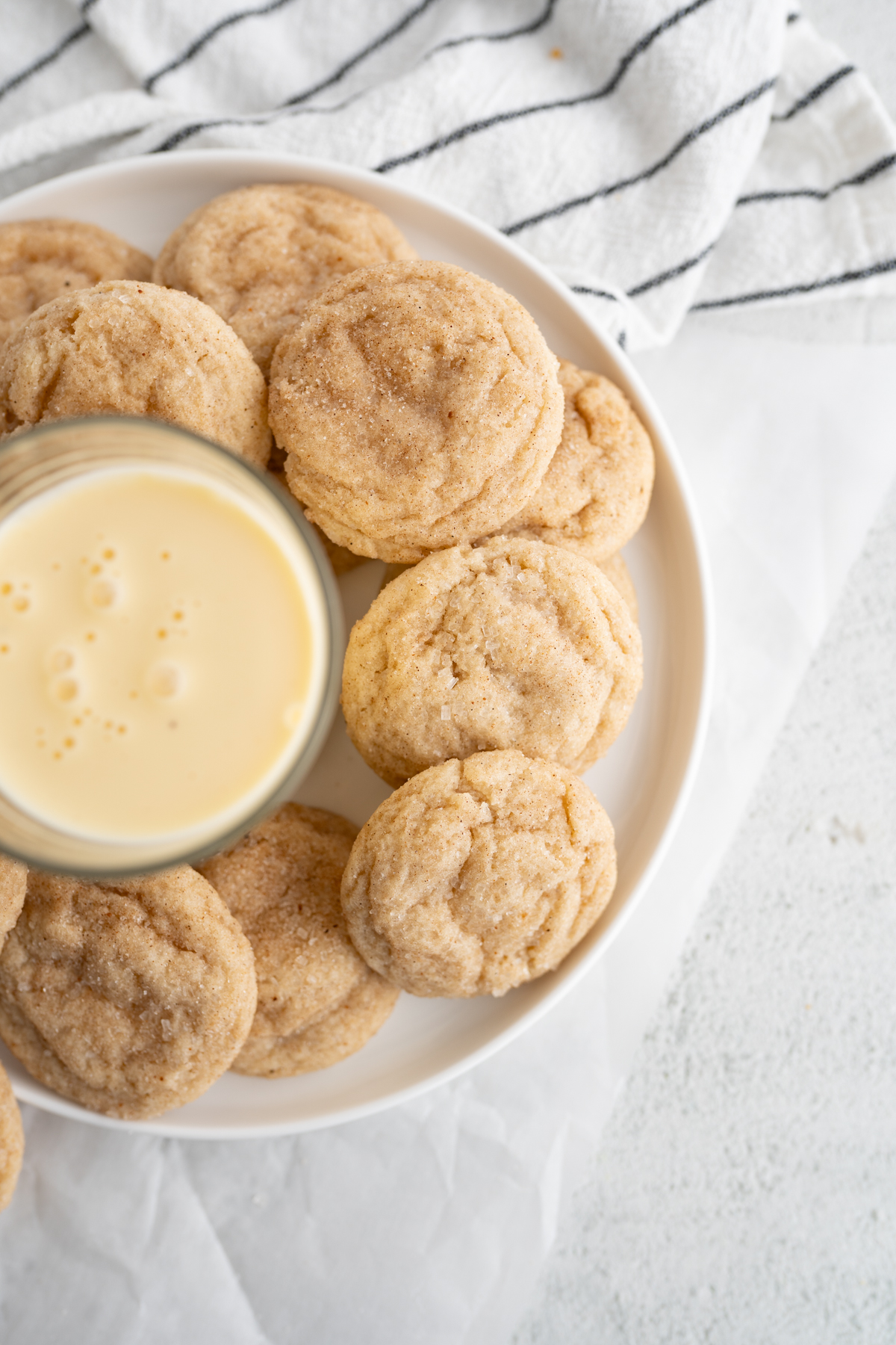 Aerial view of a glass of egg nog and christmas snickerdoodles on a plate. 