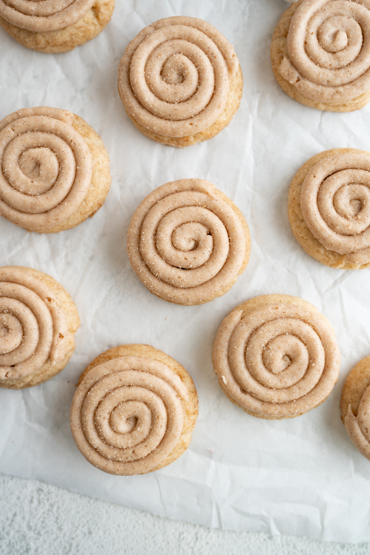 Aerial view of small churro cookies on a cookie sheet. Cookies are frosted with cinnamon buttercream. 