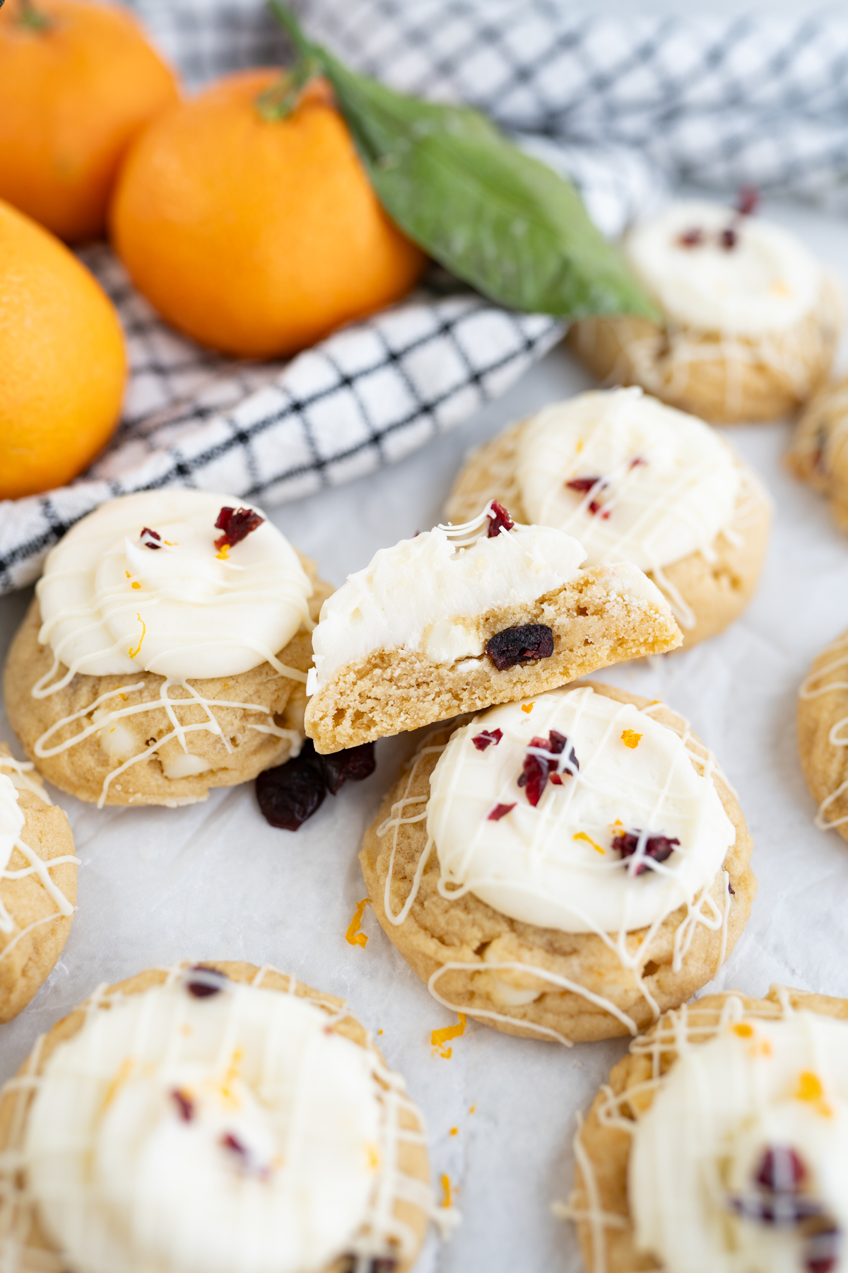 A chewy blondie cookie cut in half to reveal orange zest, craisins, and  white chocolate chips. 