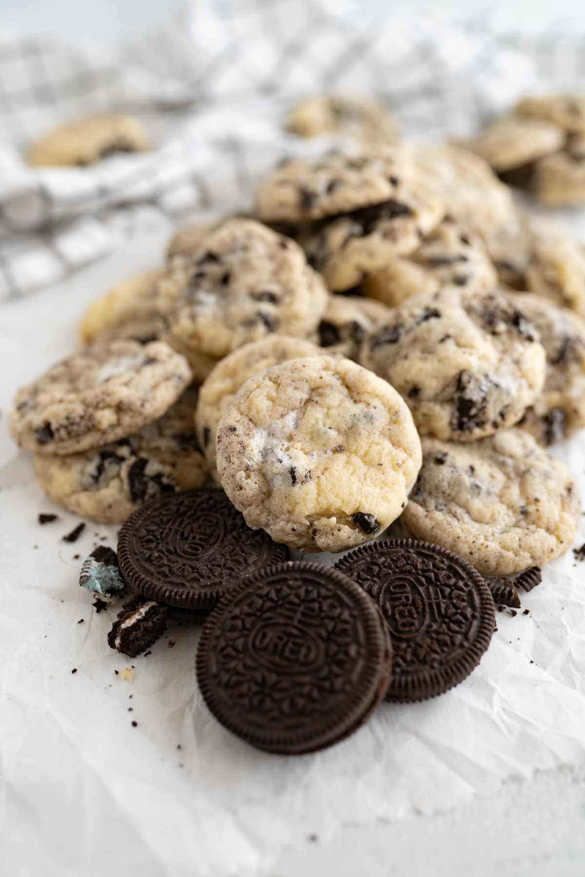 Cookies in a pile on top of Oreos. The cookies are cake batter flavored with Oreos and marshmallow fluff inside. 