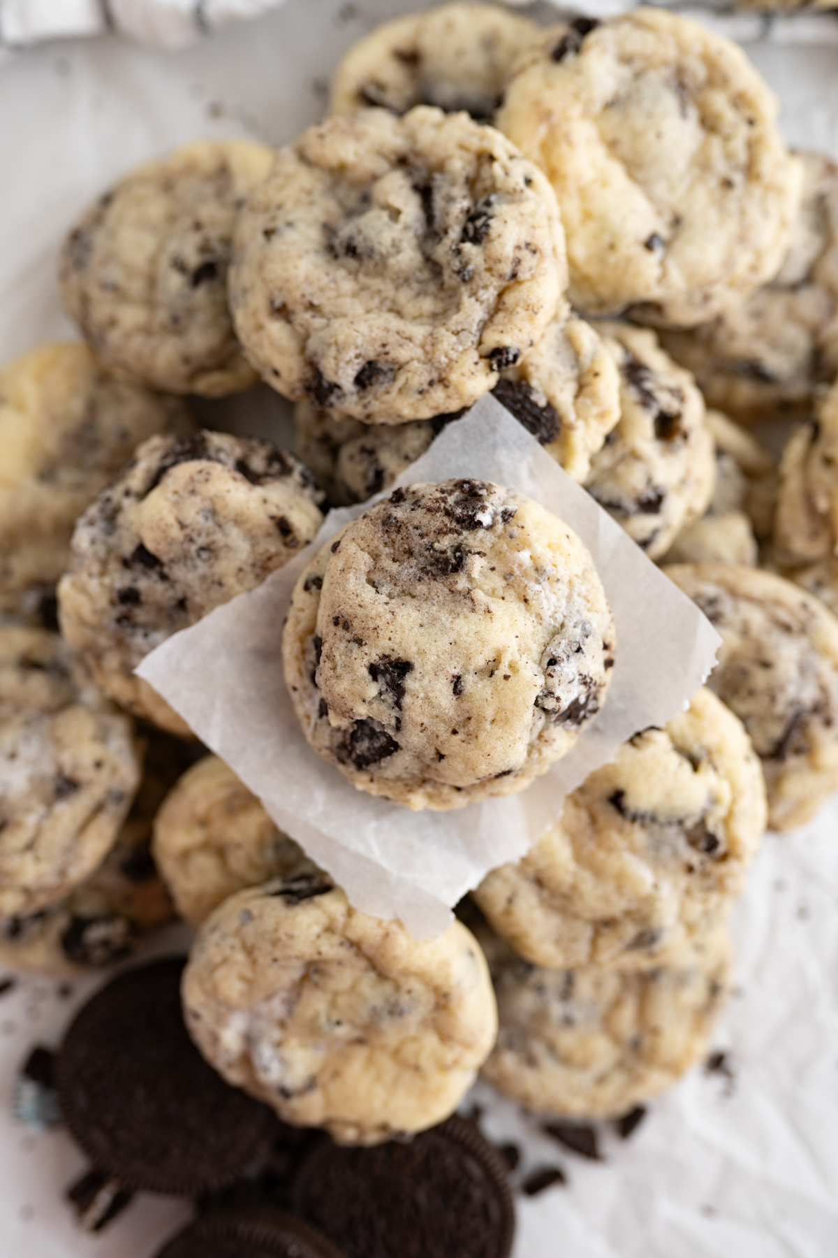 Aerial view of a cake batter oreo marshmallow fluff cookie with a bite taken out of it on a pile of other cookies. 