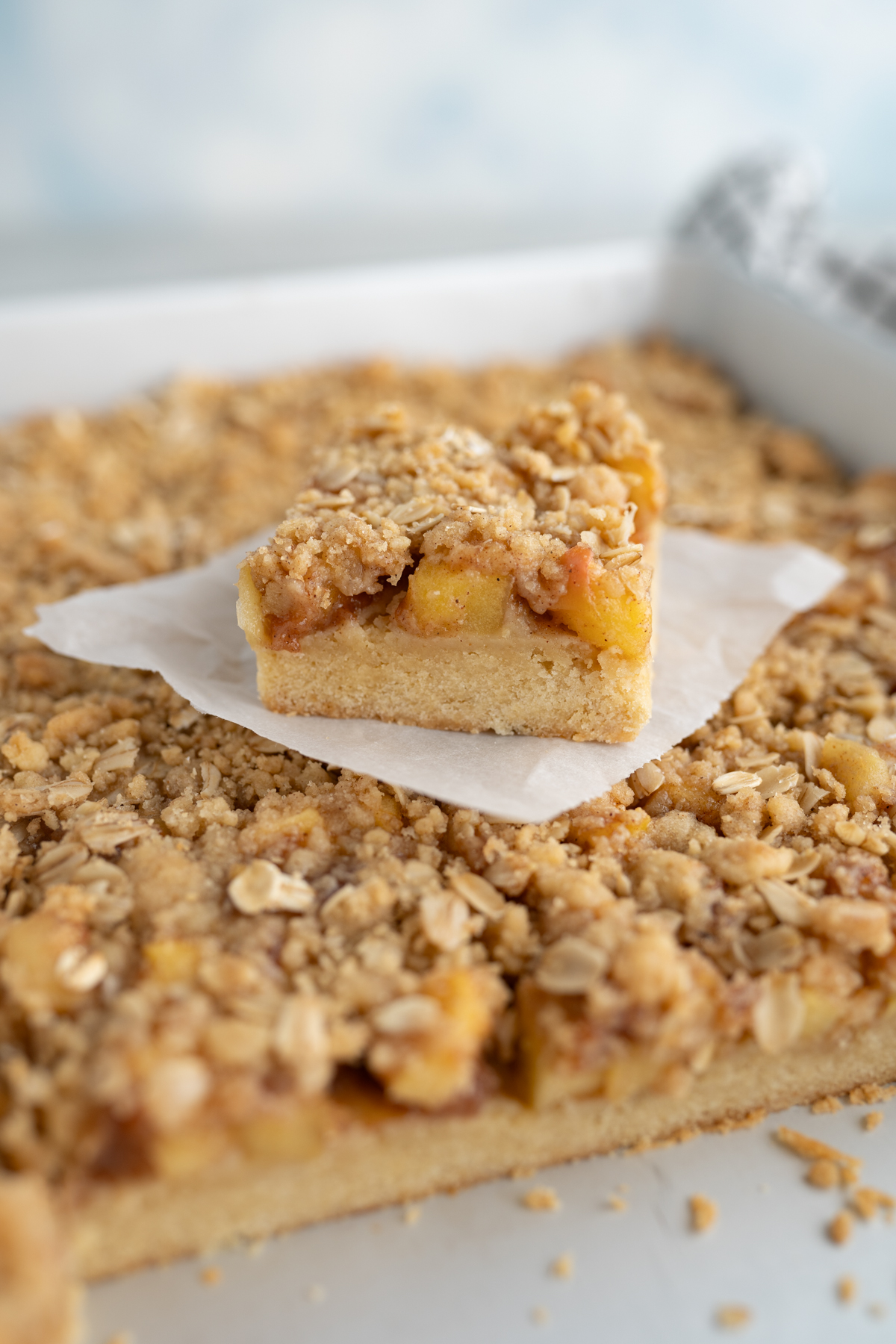 Side view of an apple crumb cookie bar with a sugar cookie base, apple filling, and crumble topping. 