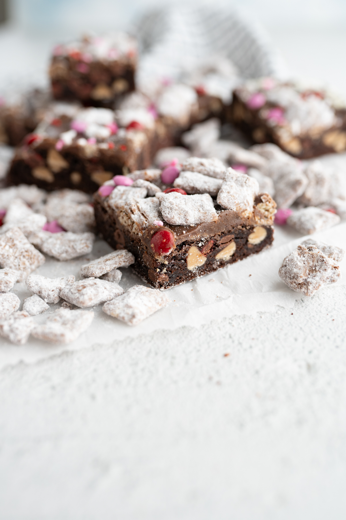 Side view of a chocolate cookie bar filled with peanut butter chips and m&ms. 