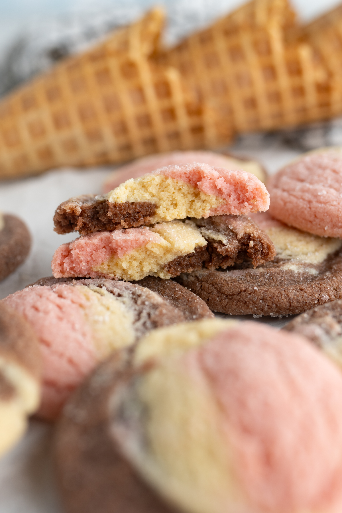 A strawberry, vanilla, and chocolate cookie cut in half to show soft interior. 