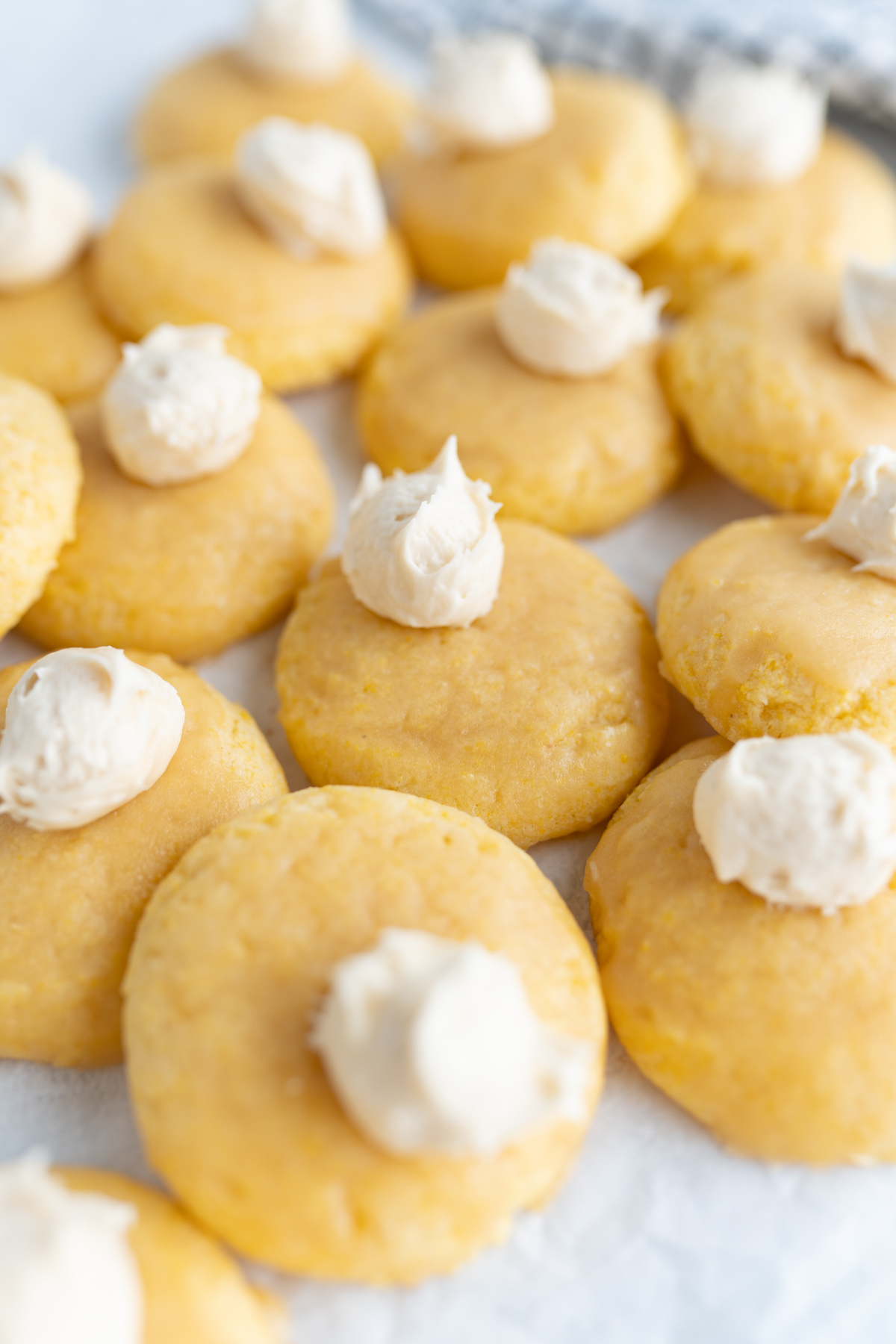 Pile of cornbread-inspired cookies topped with honey buttercream. 