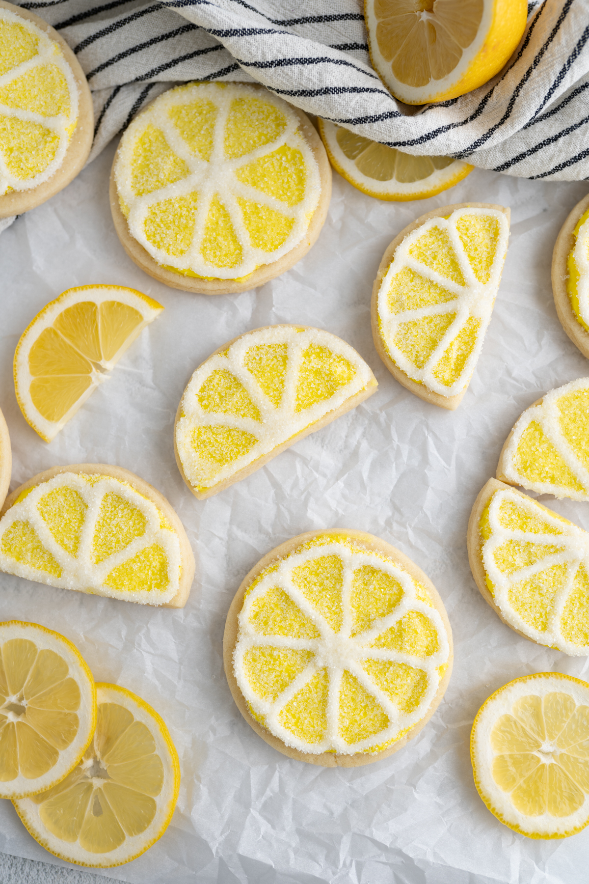 lemon sugar cookies decorated to look like lemons scattered on a countertop. 