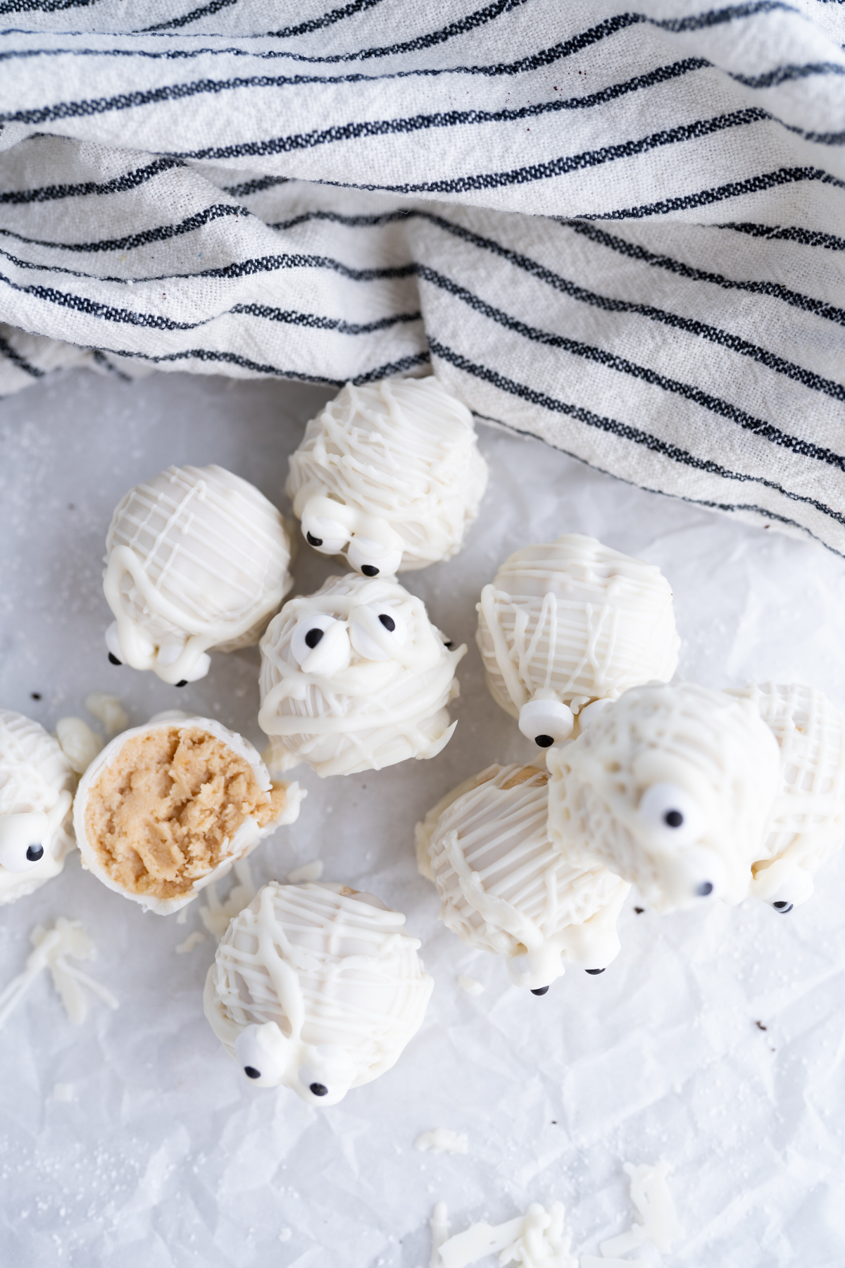 a bunch of golden oreo truffles decorated to look like mummies for halloween. 